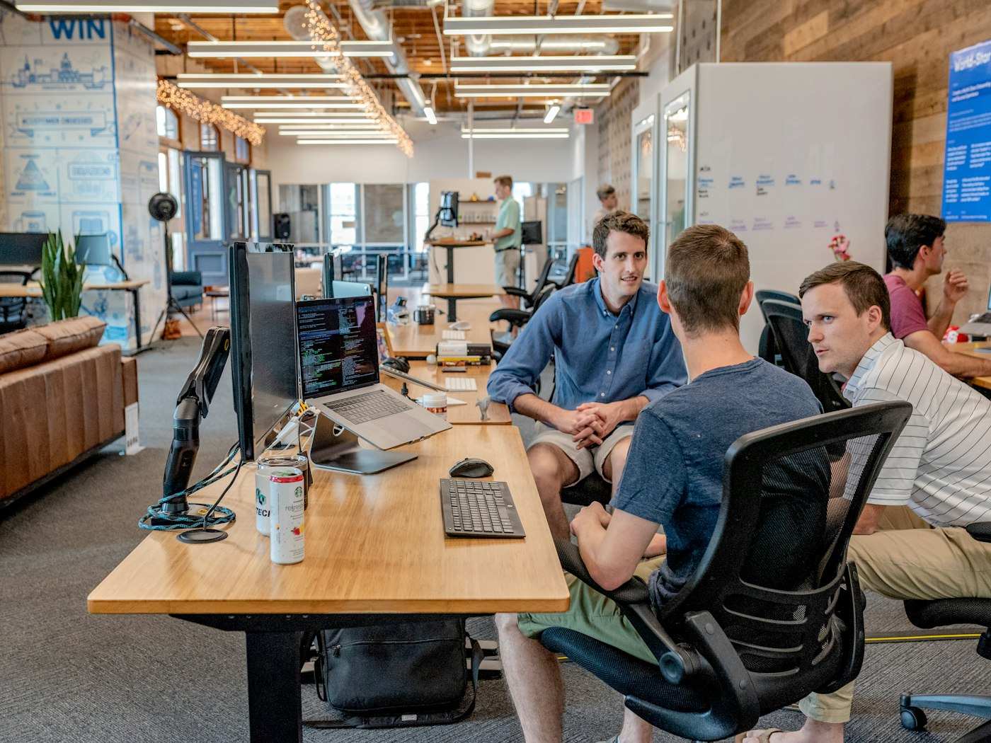 A small team in an open workspace talking through a decision together